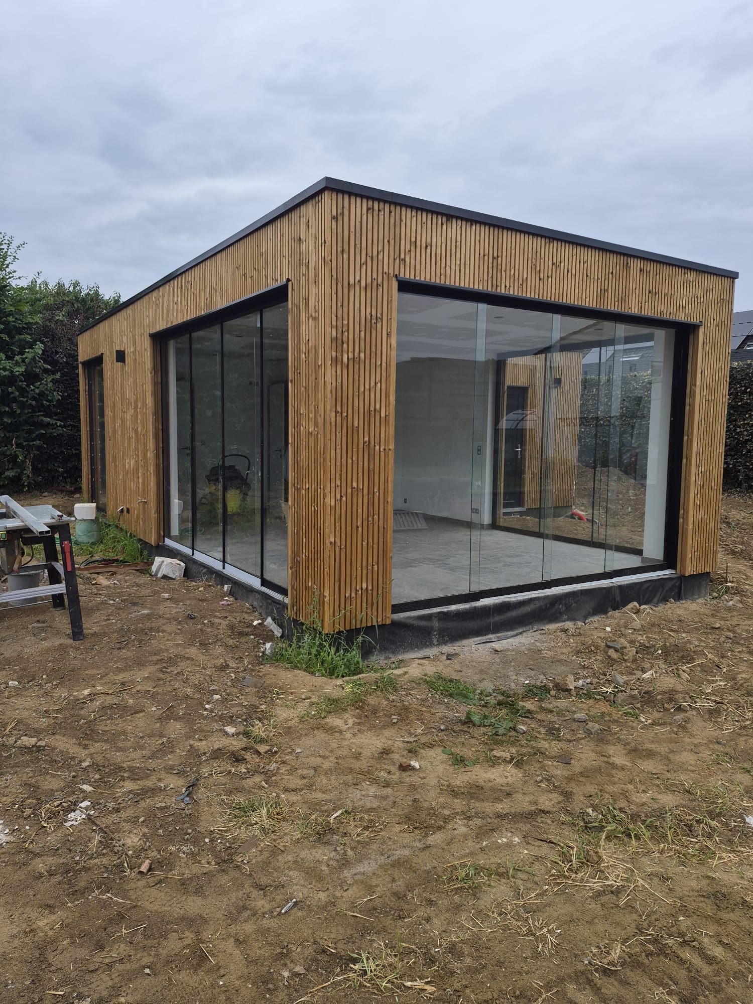 Aangelegd zwembad met houten terras en siergrassen — realisatie Jardim